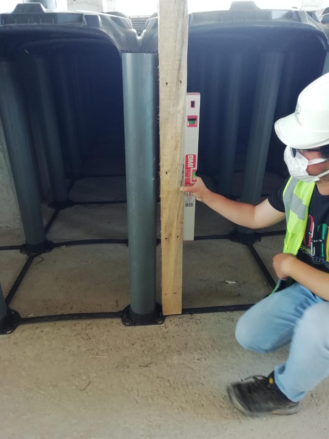 Technician inspecting tall ABS void formwork supports during installation